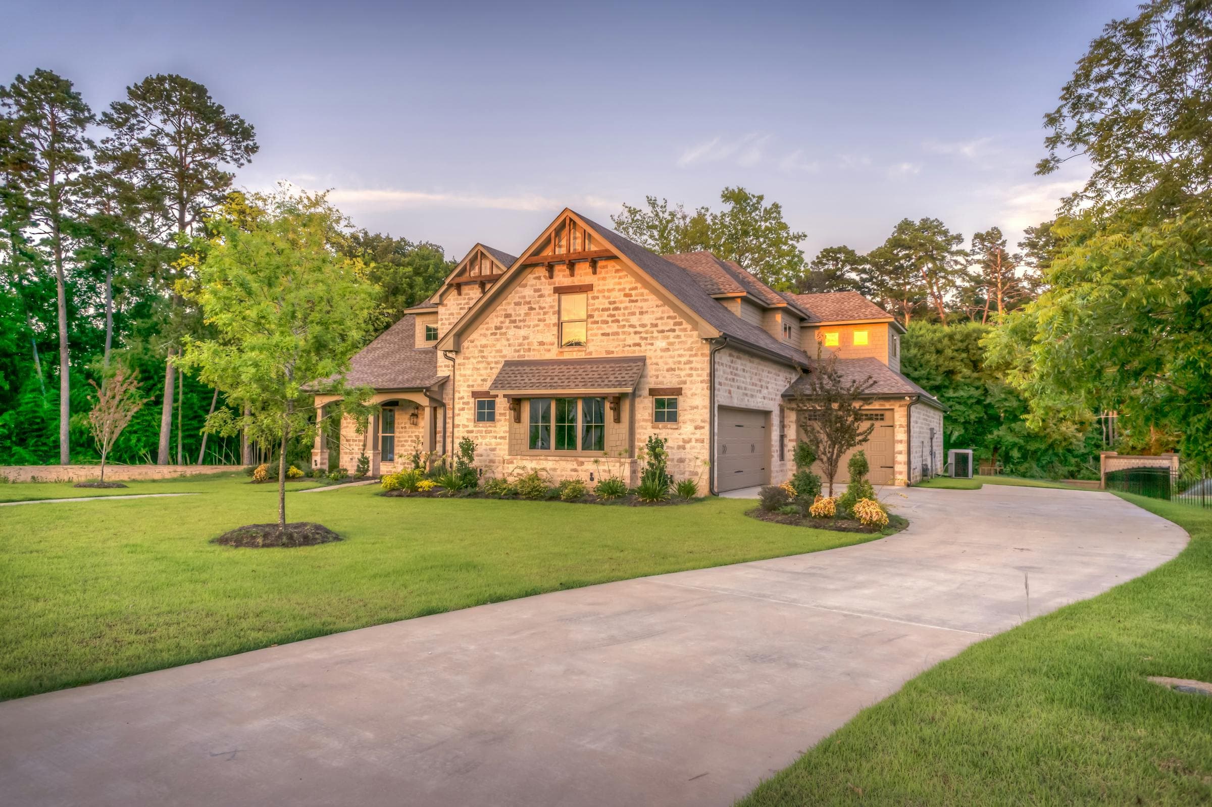 Beautiful craftsman home with wide concrete driveway in warm evening light - JSW Construction driveway widening